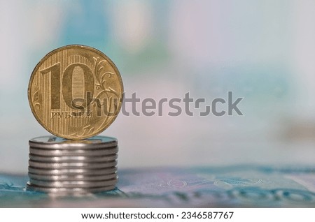 Money. 10 and 1 russian rouble coins against 1000 rubles banknotes background