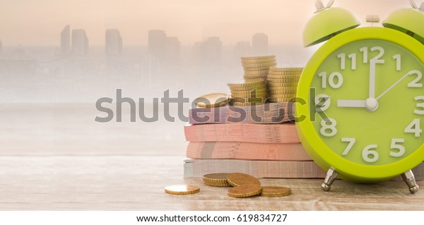 Money, alarm clock with\
city business background. Concept of retirement funds,finance, time\
is money.