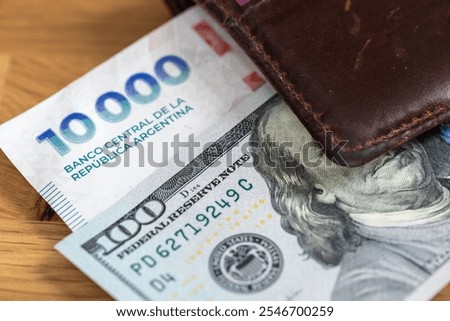 Money Argentine, peso vs dollar. Financial concept. Exchange peso to dollars. New 10,000 thousand Argentine pesos and 100 US dollars in wallet. Close up