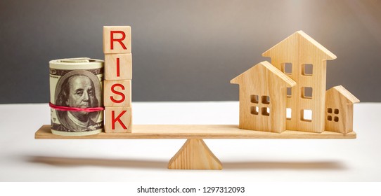 Money Bag, Blocks With The Word Risk And A Wooden House On The Scales. The Concept Of Losing Money When Investing In Real Estate. Risks Of Losing A Home Or Housing For Non-payment. Property Insurance