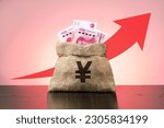 Money bag with chinese yuan and  red arrow going up. China economy bisiness going up.