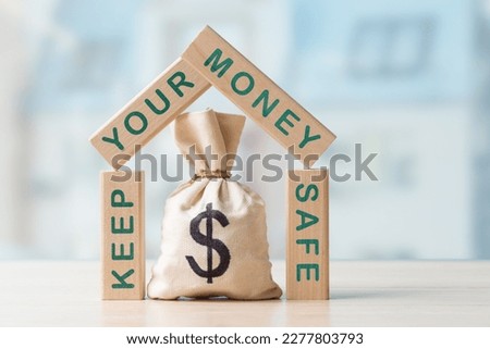 Money bag with Dollar sign in a frame of wooden blocks with words Keep Your Money Safe. Concept of money saving tips and ways. Financial strategy and planning