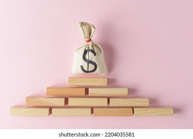Money bag with dollar symbol over blank wooden blokes pyramid - Shutterstock ID 2204035581