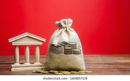 Money Bag And Government Building. Business And Finance Concept. Deposit, Loan And Investment In To The Bank. Credit. Help From The State. Subsidies And Benefits. Budget. Copy Space