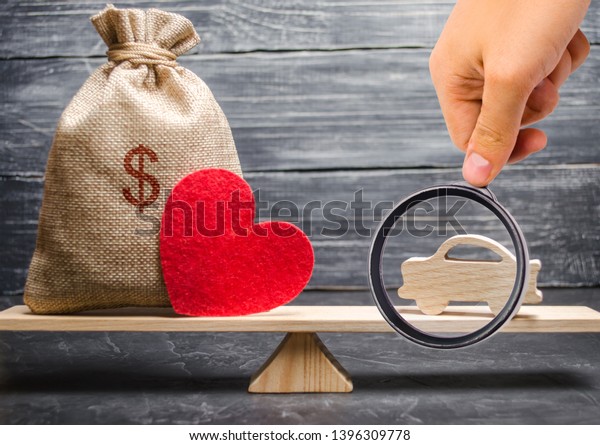 A money bag and a heart with a miniature\
wooden car on the scales. Auto insurance. Accumulation of money to\
buy a car. Saving money for a\
dream.