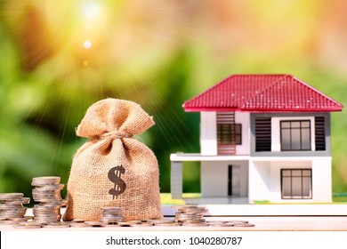 money bag and stack coin with flare , investment property, home insurance, savings plan for housing concept.