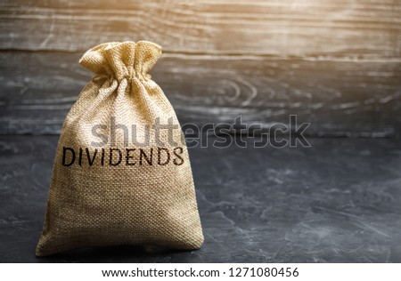 Money bag with the word Dividends. A dividend is a payment made by a corporation to its shareholders as a distribution of profits. Concept business finance and investment. Saving money. Dividend tax