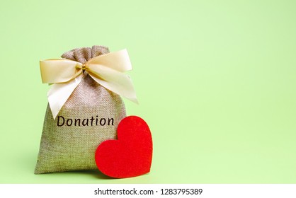 A Money Bag With The Word Donation And A Red Heart. Accumulation Of Money For A Medical Donation. Health Care. Saving. Social Medical Help From Volunteers. Charitable Foundation