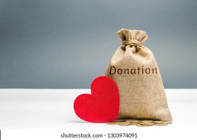 A Money Bag With The Word Donation And A Red Heart. Accumulation Of Money For A Medical Donation. Health Care. Saving. Social Medical Help From Volunteers. Charitable Foundation