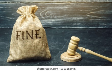 Money bag with the word Fine and the judge's hammer. Penalty as a punishment for a crime and offense. Financial punishment. Violations of traffic laws. Fraud. Fines can also be used as a form of tax - Shutterstock ID 1313185946