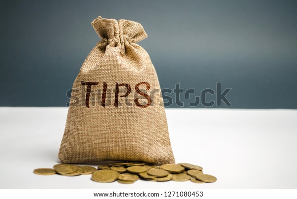 Money bag with the word Tips. Award for good\
service in the cafe / restaurant. A gratuity is a sum of money\
customarily given by a client or customer to a service worker in\
addition to the basic\
price