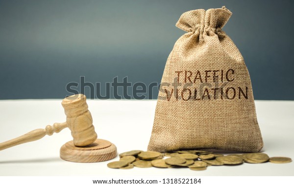 Money bag with the word Traffic violation and\
the judge\'s hammer. Law. Court. Fine, legal fees. Traffic Tickets.\
Speeding. Failure to yield. Turning into the wrong lane. The\
layer\'s services