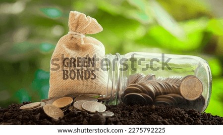Money bag with the words GREEN BONDS with coins and a glass jar investment in bond concept Raising funds to fund environmentally friendly projects green bond