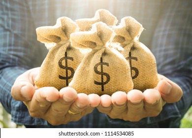 Money bags in man hand show savings money and savings to buy a home or buy real estate or car. Or show a home loan or divide the investment for retirement. Or for the future Concept of money.