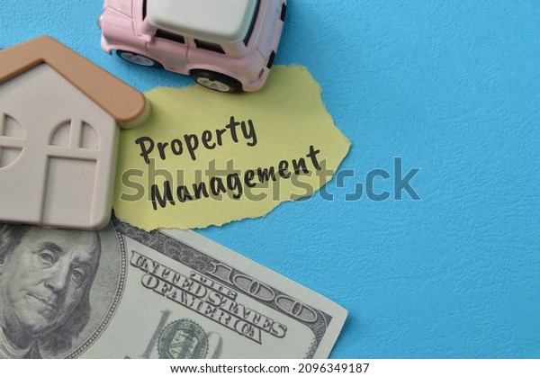 Money banknote, toy car and toy house with\
text PROPERTY MANAGEMENT