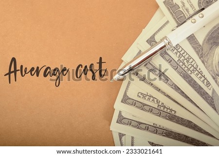 Money banknotes and pen with text AVERAGE COST. average cost of a product or service