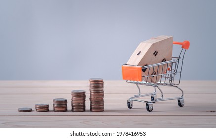 Money, Bar Coins, Graphs And Model House Model Is Placed On A Shopping Cart In The Mall.using As Background Business Concept And Real Estate Concept.