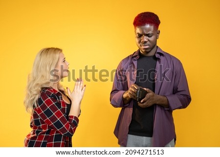 Money borrow. Financial problem. Economic crisis. Budget management. Hopeless broke woman begging for favor to insecure man with wallet isolated on orange background.