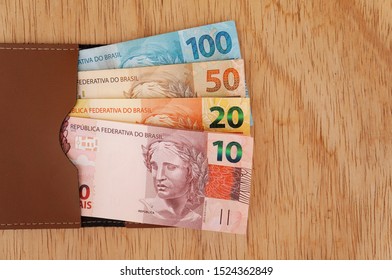 Money in a brown wallet. Brazilian money. Real. Brazilian currency on wood background.  - Shutterstock ID 1524362849