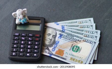 Money And Calculator With A Kids Toy On A Table; Child Stimulus Tax Credit Concept