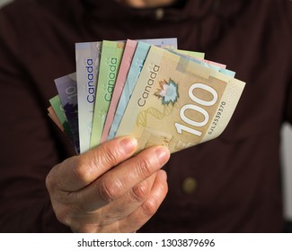 Money From Canada: Canadian Dollars. Old Retired Person Paying In Cash.