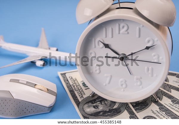 money, clock, airplane model \
and computer mouse on blue background, Balance working\
concept.