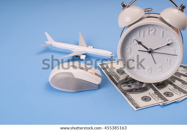 money, clock, airplane model \
and computer mouse on blue background, Balance working\
concept.