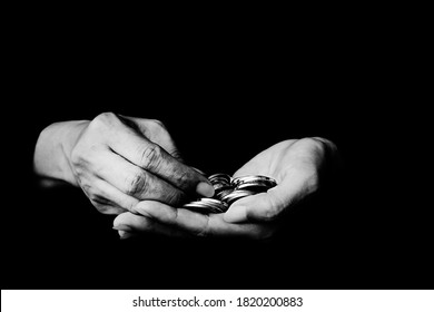 Money Coin In Hand Black And White Photo On Black Background - Black And White Photo Of Coins In Old Wrinkled Hands Close-up