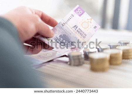 Money, coins, debts, pink bills and finances. Mexican pesos