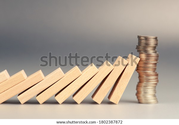 Money coins heap still balance and stop\
the falling domino, financial stability\
concept