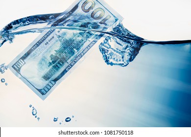 Money concept. US Dollar sinking in water as symbol of global financiall crisis and uncertain future of international trade and investment. 