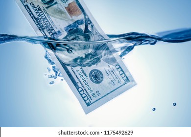 Money concept. US Dollar sinking in water as a symbol of global economic crisis
