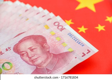 Money / currency of PBOC or people's bank of china. One hundred CNY Chinese yuan bill with a flag of China. 100 rmb or renminbi, depicts Beijing economy system, public banking policy and interest rate
