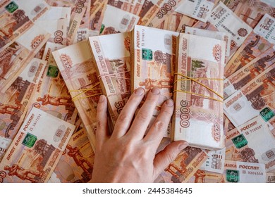 a lot of money in the denomination of five thousand Russian rubles against the background of the entire photograph and a stack of money tied with rubber bands, stacks of five thousandth banknotes and 