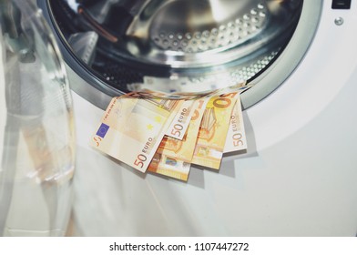 Money (euro) put to dry on the edge of the washing machine with the door opened, close up. Money laundering symbol