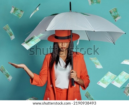 Money, fashion and rich lady being showered by cash while holding umbrella for insurance, protection and cover showing her wealth after payout. Winning luxury woman with dollar bills in the air