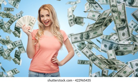 Money, Finances, Investment, Saving And People Concept - Happy Young Woman With Dollar Cash Over Money Rain And Blue Background