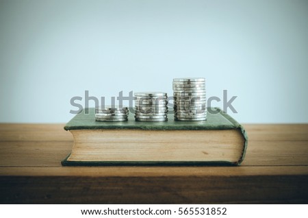 Money, Financial, Business Growth concept, Coin stacks on old book. Vintage filter.