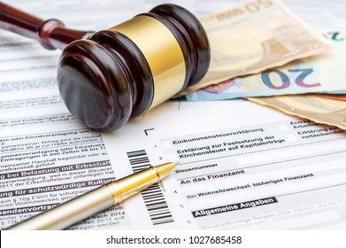 Money, gavel and pen on the German tax form. Translation:(Income tax declaration, tax number, to the tax office, change of domicile, general information)