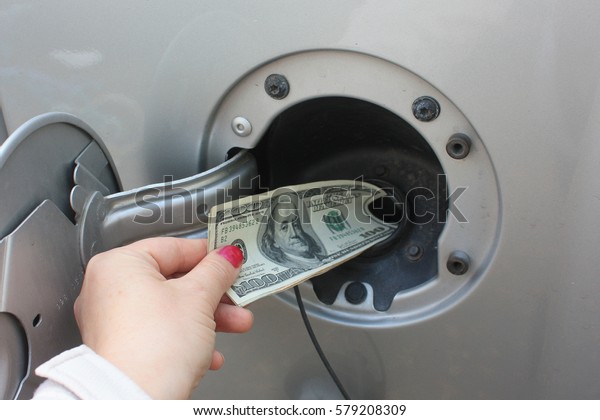 Money Getting Dumped Into\
Gas Tank