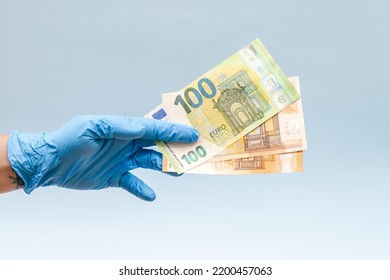 Money In Hand In Blue Surgical Glove, Nurse Or Doctor. Corruption.