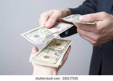 Money in the hands of the people. Convert dollars on gray background