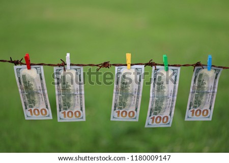 Money Laundering. Money Laundering US Dollars Hung Out To Dry. 100 Dollar Bills Hanging On Rusty Barbed Wire