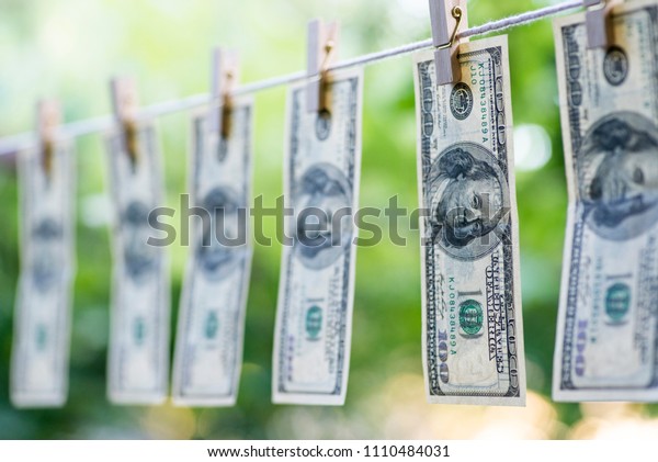 Money Laundering. Money\
Laundering US dollars hung out to dry. 100 dollar bills hanging on\
clotheslines