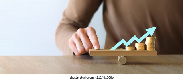 Money leverage and inflation balance. Businesswoman Balancing Stacked Coins With Finger On Wooden Seesaw. Financial concept