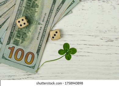 Money And Luck Concept With 100 Dollar Bills A Four Leaf Clover And A Pair Of Dice With A Roll Of Seven