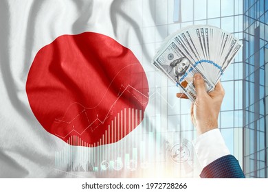 Money in a man's hand against the background of the flag of Japan. Japanese income. The financial condition of the inhabitants of Japan, taxes, loans, mortgages. Government debt of Japan - Shutterstock ID 1972728266