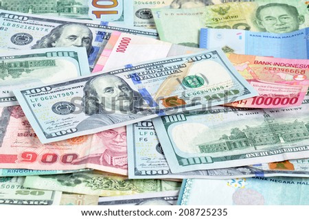 Money in multi currencies with 100 USD bill on top