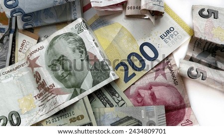 Money on its own against a white background. Various Turkish lira notes accompanied by US dollars and euros on a bright surface.

