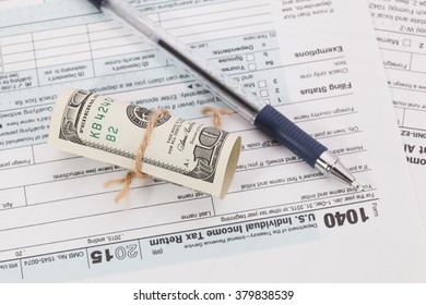 Money and pen on tax form background